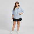 Camisa azul con lazo frontal y cuentas